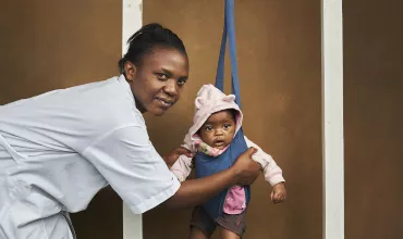 Doctor in Rwanda weighing a baby